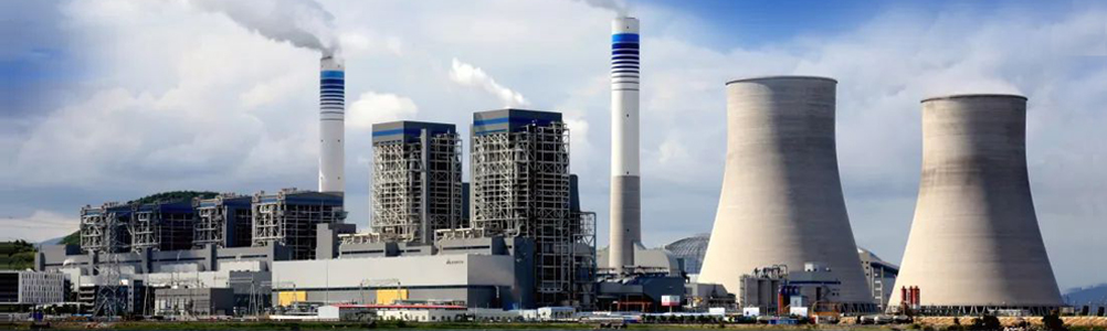 Industrial power plant with tall cooling towers and smoke stacks under blue sky, gray and white tones